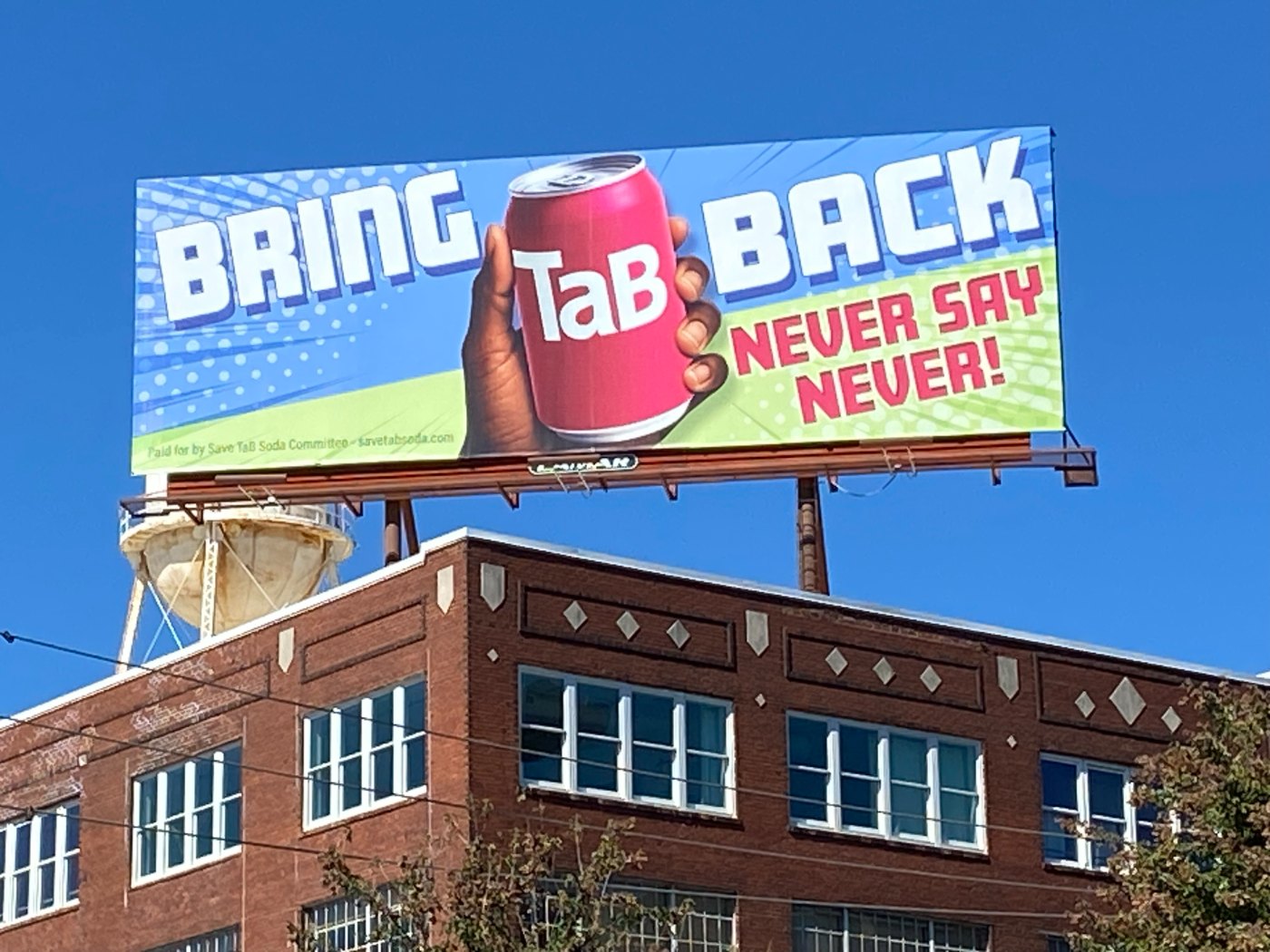 Billboard reading Bring TaB Back — Never Say Never on a rooftop in Atlanta