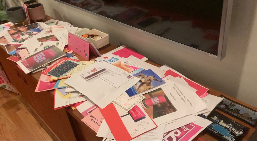 A table covered with hundreds of handwritten birthday cards for TaB
