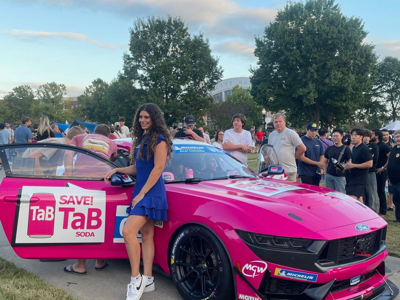 A bright pink race car wrapped with Save TaB Soda branding at an Atlanta event