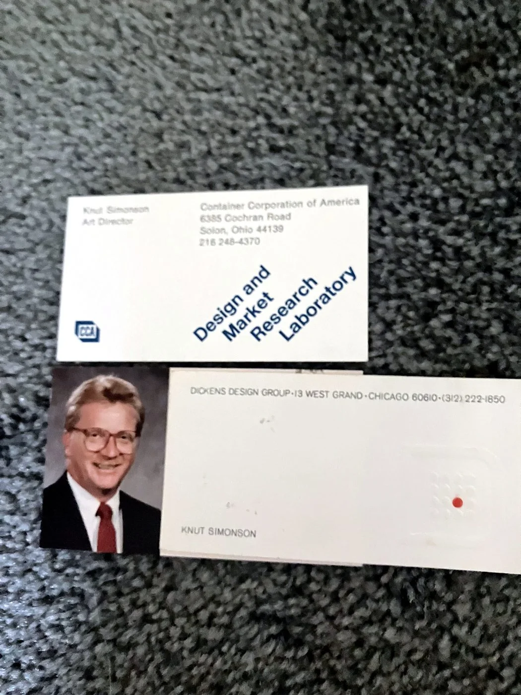 Two of Knut Simonson's business cards, one from Container Corporation of America listing him as Art Director and one from Dickens Design Group in Chicago, beside his employee portrait from the era.